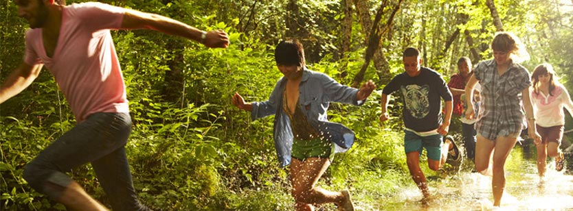 group of teens running through forest